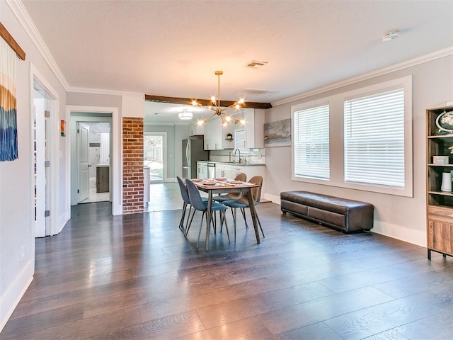 dining space featuring a chandelier, crown molding, dark wood-type flooring, and sink