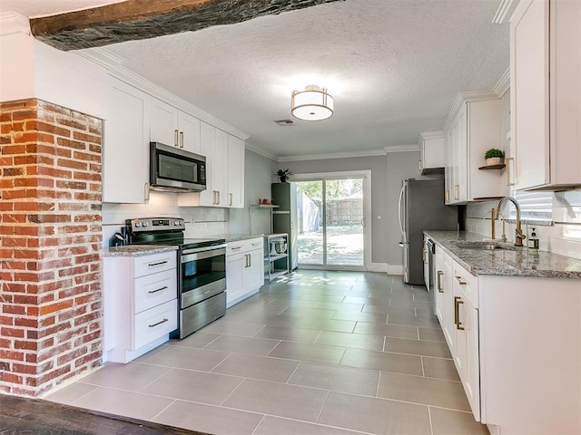 kitchen featuring light stone counters, sink, white cabinets, and appliances with stainless steel finishes