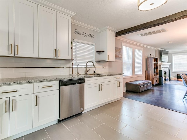 kitchen with a wealth of natural light, white cabinetry, dishwasher, and sink