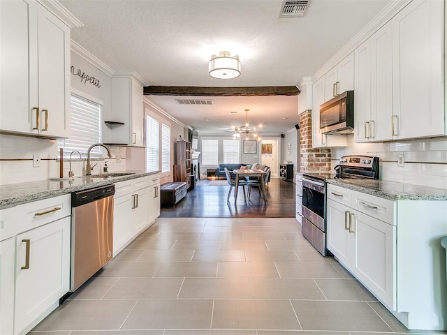 kitchen featuring light stone countertops, sink, white cabinets, and appliances with stainless steel finishes