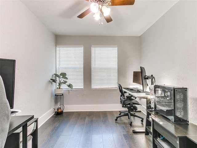 home office with dark hardwood / wood-style flooring and ceiling fan