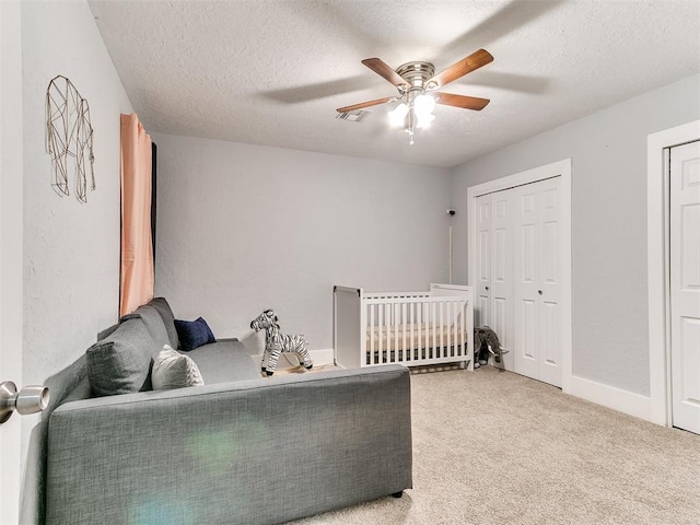 carpeted bedroom featuring a textured ceiling, a closet, and ceiling fan