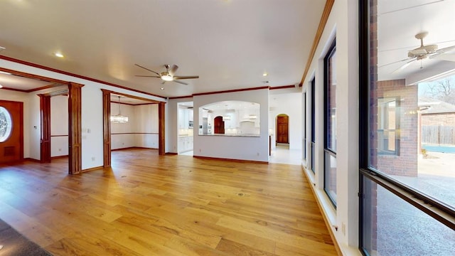 unfurnished living room featuring ceiling fan, light wood-type flooring, and ornamental molding