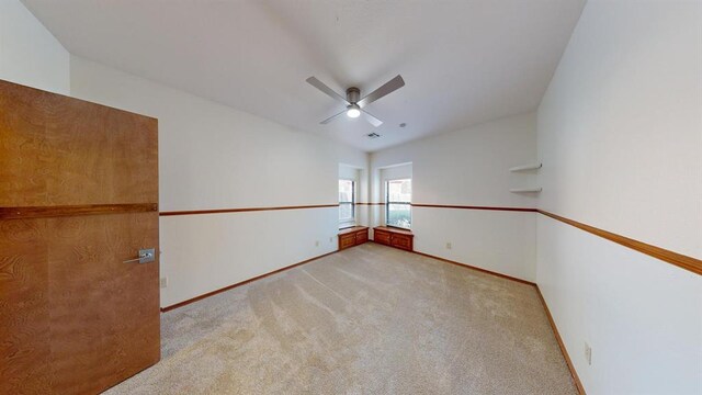 carpeted spare room with ceiling fan