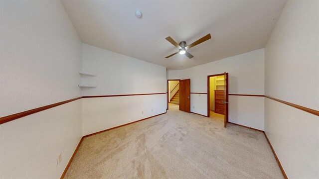 interior space with ceiling fan and light colored carpet