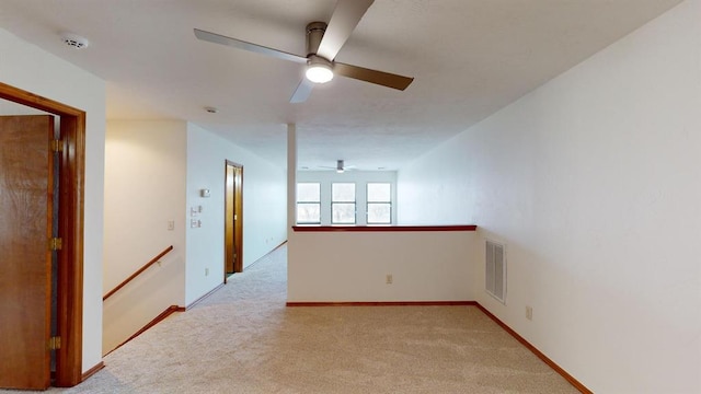 unfurnished room featuring light colored carpet and ceiling fan