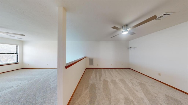 carpeted spare room featuring ceiling fan