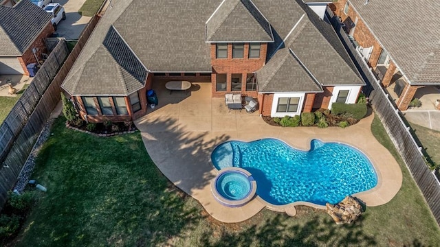 exterior space featuring a lawn, an in ground hot tub, and a patio