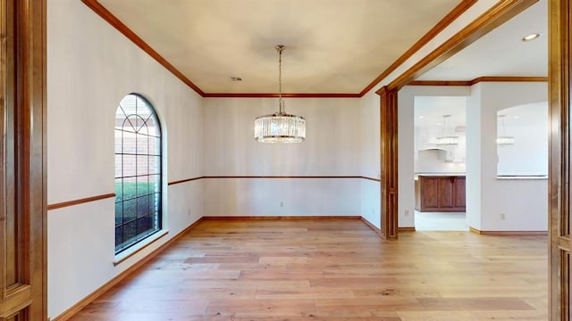 interior space featuring light wood-type flooring, ornamental molding, and an inviting chandelier