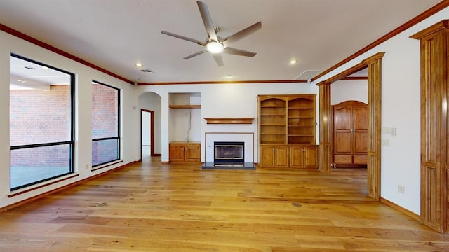 unfurnished living room with light hardwood / wood-style flooring, ceiling fan, and crown molding