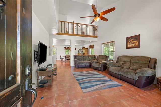 tiled living room featuring a towering ceiling and ceiling fan