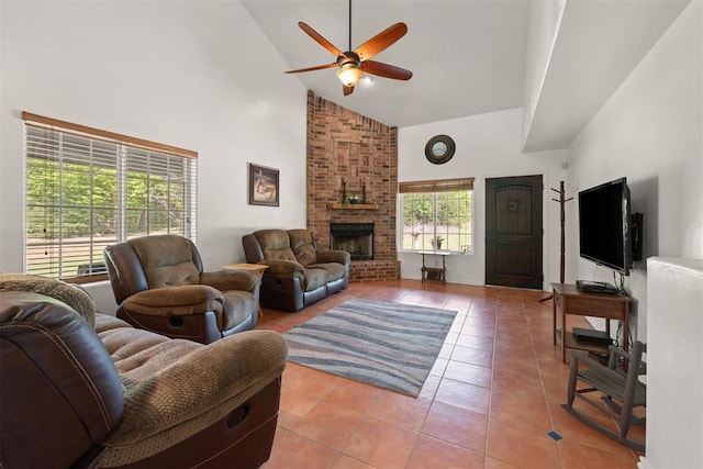 tiled living room featuring a brick fireplace, high vaulted ceiling, plenty of natural light, and ceiling fan