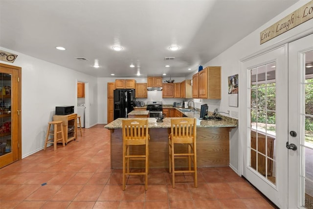 kitchen with french doors, black refrigerator with ice dispenser, stainless steel range oven, kitchen peninsula, and a breakfast bar area