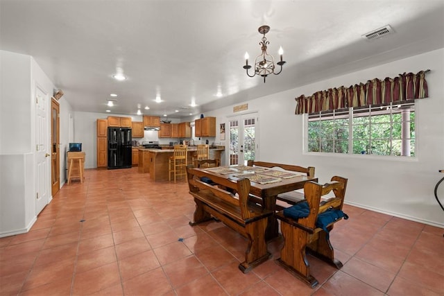 tiled dining area with french doors and an inviting chandelier