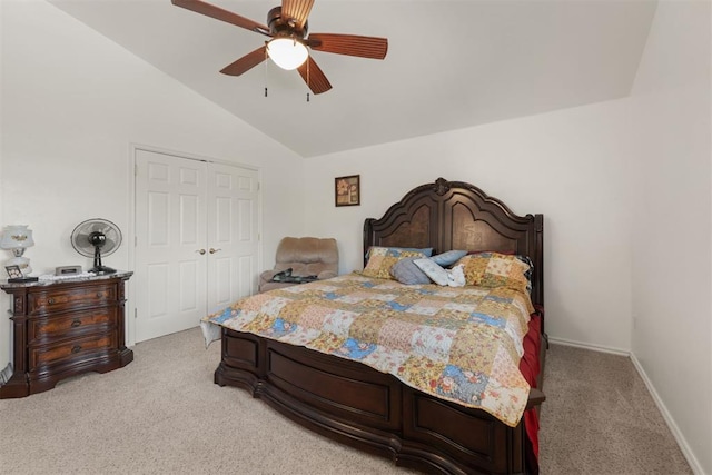 carpeted bedroom with a closet, lofted ceiling, and ceiling fan