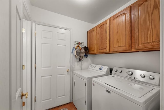 laundry area featuring light tile patterned floors, cabinets, and independent washer and dryer