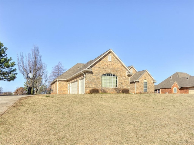 view of front facade with a front lawn, an attached garage, and brick siding