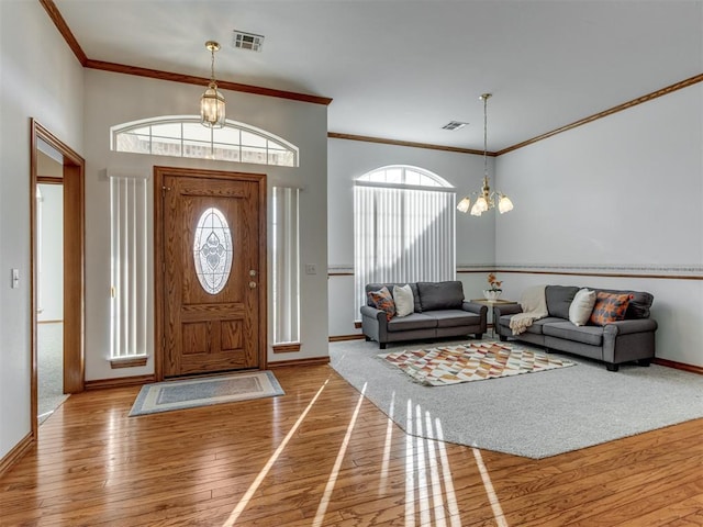 entryway with plenty of natural light, visible vents, an inviting chandelier, and hardwood / wood-style floors