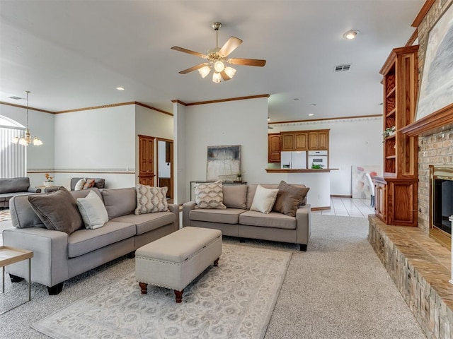 living room featuring visible vents, crown molding, a brick fireplace, ceiling fan with notable chandelier, and light colored carpet