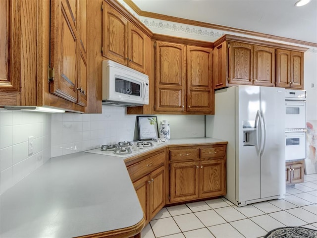 kitchen with white appliances, light tile patterned floors, brown cabinets, light countertops, and tasteful backsplash