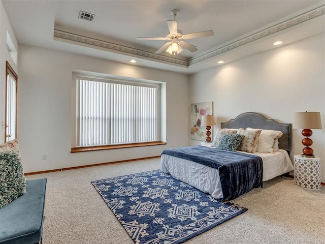 carpeted bedroom with visible vents, ceiling fan, a raised ceiling, and baseboards