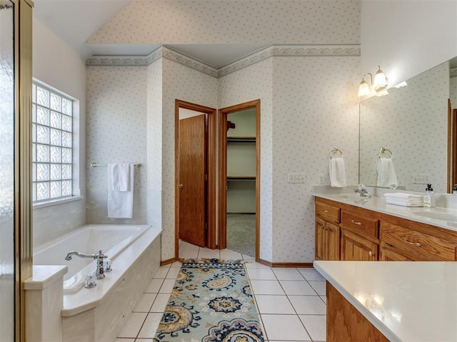 full bath with tile patterned floors, a sink, wallpapered walls, baseboards, and a bath