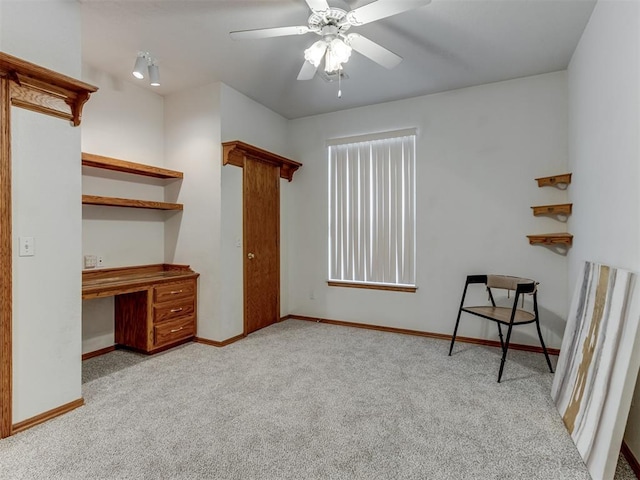 interior space with a ceiling fan, carpet, and baseboards