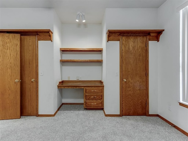 interior space featuring baseboards, carpet floors, and built in study area