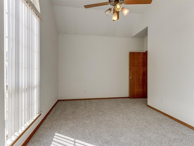 interior space featuring vaulted ceiling, baseboards, carpet floors, and ceiling fan