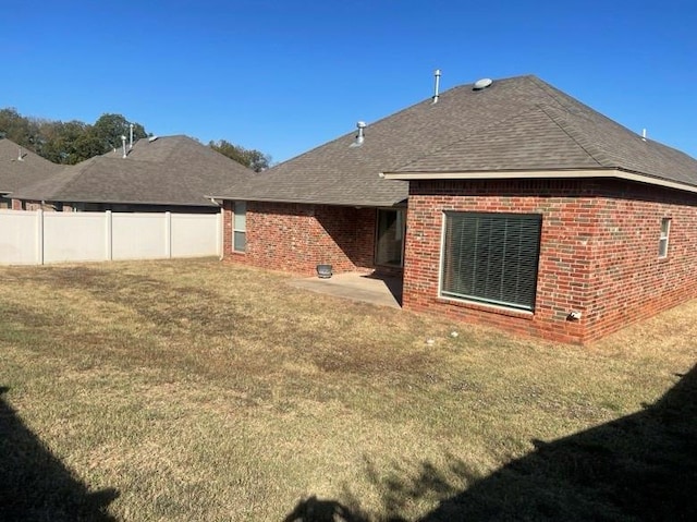 back of property with a lawn and a patio area