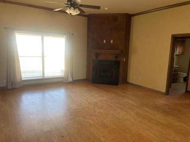 unfurnished living room with a fireplace, crown molding, light hardwood / wood-style flooring, and ceiling fan