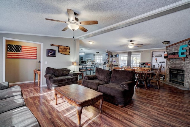 living room with ceiling fan, a brick fireplace, wood finished floors, and crown molding