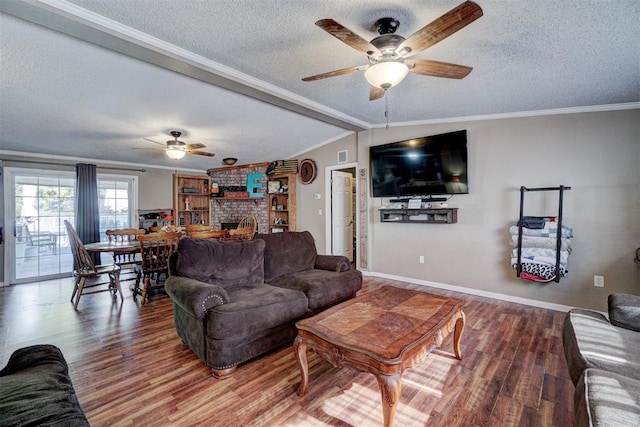 living room with crown molding, a brick fireplace, wood finished floors, and a textured ceiling