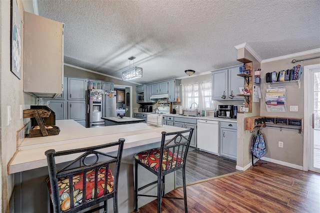 kitchen featuring stainless steel fridge with ice dispenser, range, a peninsula, white dishwasher, and a sink