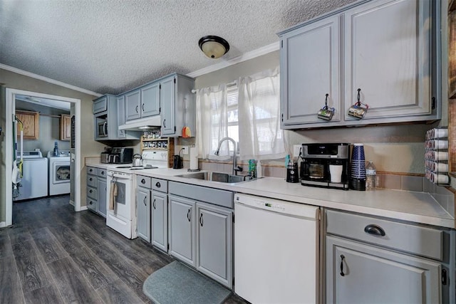 kitchen featuring under cabinet range hood, dark wood-style floors, independent washer and dryer, white appliances, and a sink