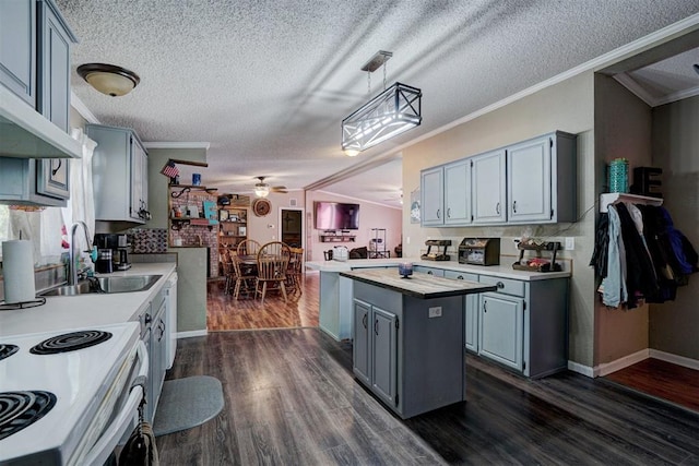 kitchen with ceiling fan, light countertops, ornamental molding, gray cabinets, and a sink