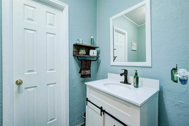 bathroom with vanity and a textured wall