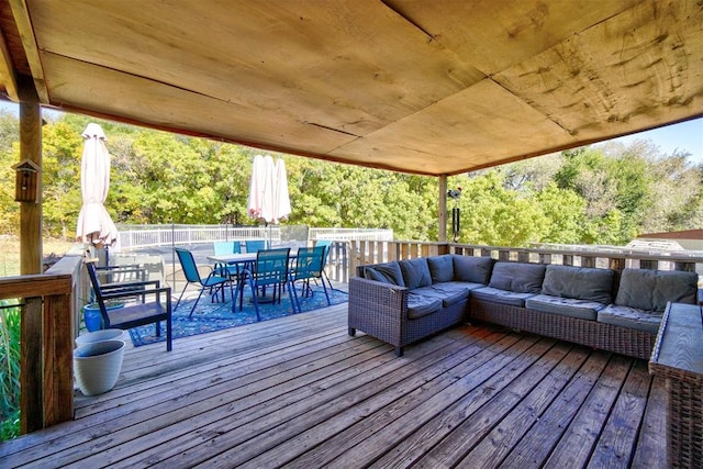 wooden terrace with outdoor dining space and outdoor lounge area