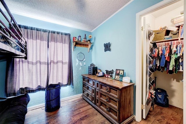 interior space with crown molding, wood finished floors, and a textured ceiling