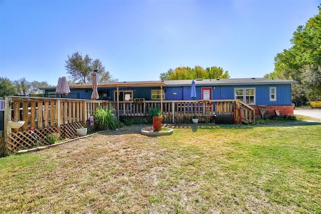 back of property featuring a wooden deck and a lawn