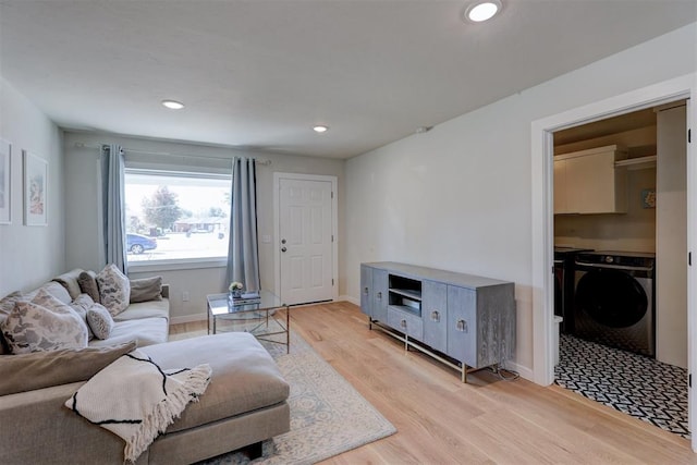 living room with independent washer and dryer and light wood-type flooring