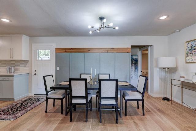 dining room with light hardwood / wood-style floors and an inviting chandelier