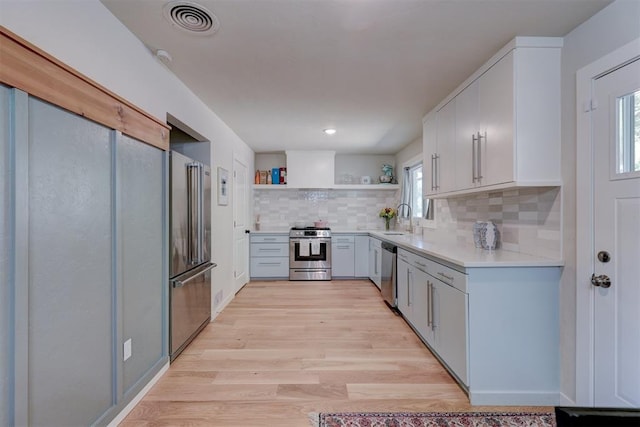 kitchen featuring plenty of natural light, white cabinets, stainless steel appliances, and sink