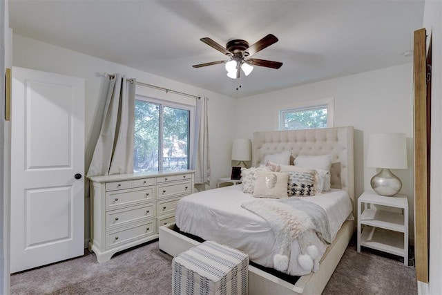 carpeted bedroom featuring ceiling fan and multiple windows