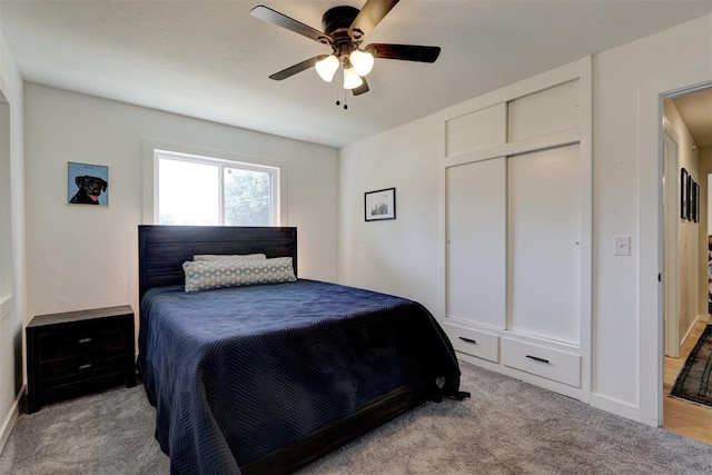 bedroom featuring ceiling fan, light colored carpet, and a closet