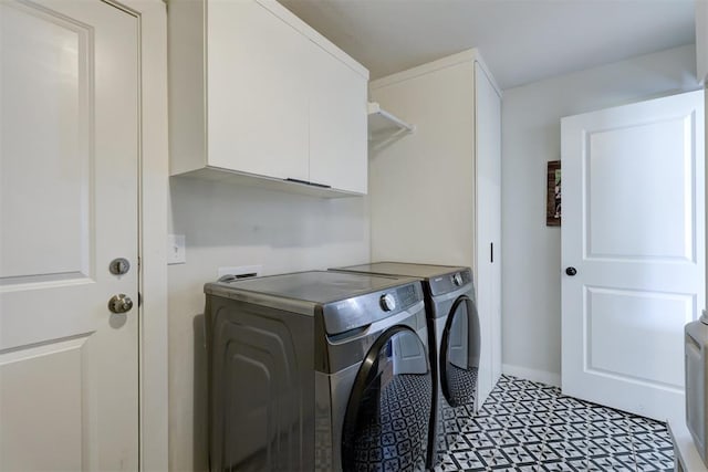 washroom with washing machine and clothes dryer and cabinets