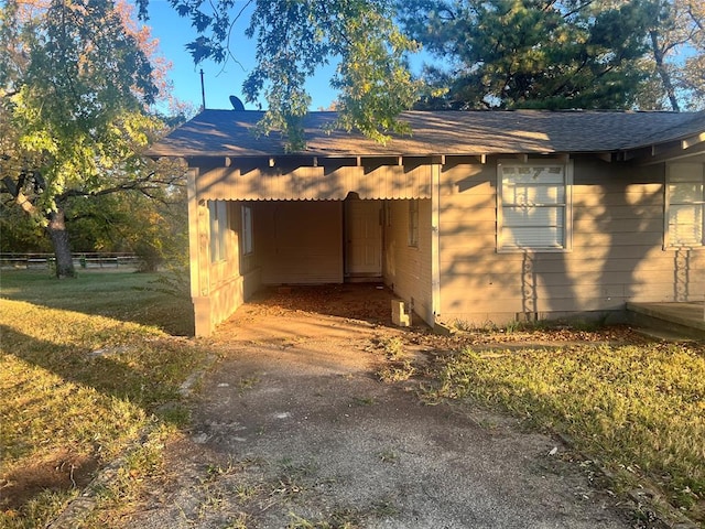 view of side of property with a lawn and a carport