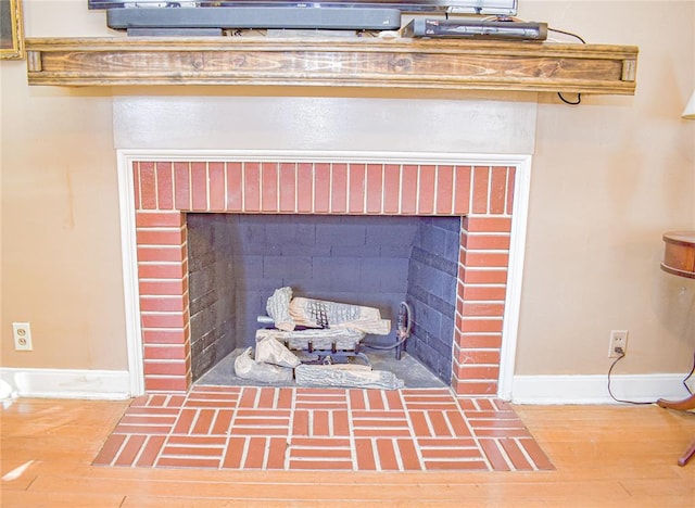 room details with wood-type flooring and a brick fireplace