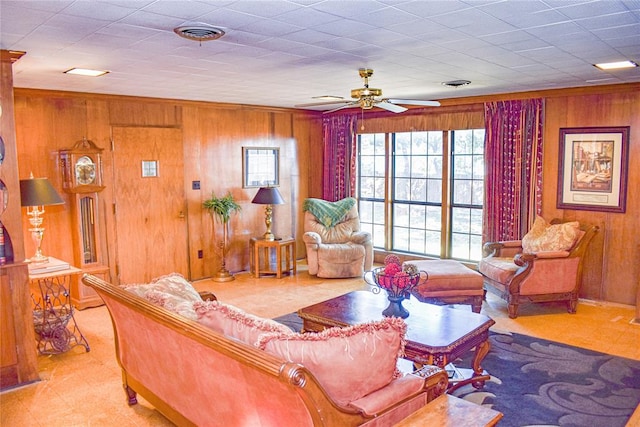 living room with ceiling fan and wood walls