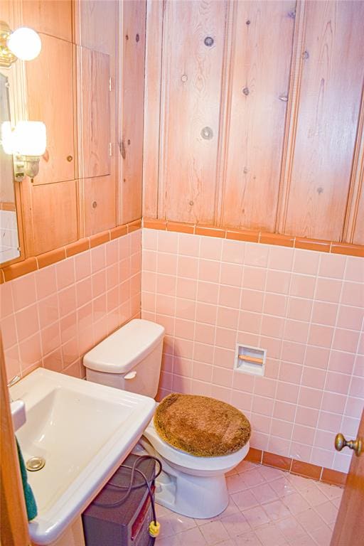 bathroom with tile patterned floors, sink, tile walls, and toilet